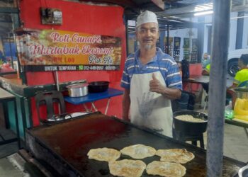 MOHD. Ghazali Hussin tidak berasa rugi walaupun menjual roti canai dan martabak mini pada harga RM1 ketika ditemui di gerainya di Kelang Lama, Kulim, Kedah. – UTUSAN/AZAHAR HASHIM