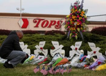 SEORANG lelaki meletakkan bunga di sebuah tugu peringatan mangsa yang terbunuh dalam kejadian tembakan beramai-ramai di pasar raya Tops di Buffalo, New York Mei lalu.-AFP