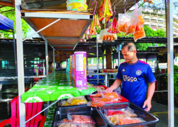 SEORANG peniaga di tepi jalan Batu Feringghi, Nazri Mustafa menyusun makanan ringan di gerainya yang mungkin akan dirobohkan pada bila-bila masa oleh MBPP.