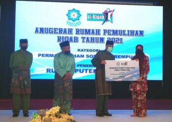 ABDUL Aziz Mohd. Yusof menyerahkan replika cek kepada wakil Rumah Puteri Arafiah pada program penyampaian geran pemulihan Riqab MAIS dekat Wisma PKPS di Shah Alam, Selangor, malam tadi. - UTUSAN / ABDUL RAZAK IDRIS