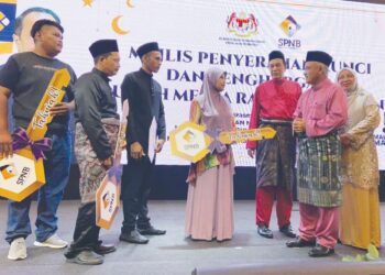 KETUA Setiausaha Kementerian Pembangunan Kerajaan Tempatan (KPKT), Datuk M. Noor Azman Taib (kanan) beramah mesra dengan penerima pada Majlis Penyerahan Kunci dan Penghargaan Rumah Mesra Rakyat (RMR) SPNB di Kota Bharu, Kelantan. -  UTUSAN/ROSMIZAN RESDI