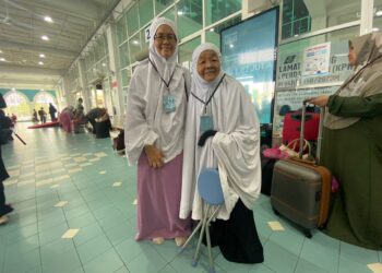ARPAH Sulaiman (kanan) teruja dapat menunaikan haji buat kali kedua selepas 24 tahun yang mana kali ini dia ditemani anak kelimanya, Noor Azlina Jahran (kiri). - UTUSAN/NORHAFIZAN ZULKIFLI