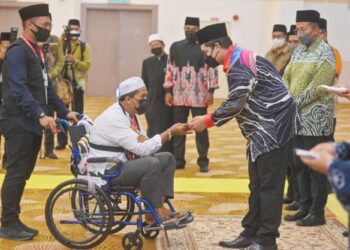 AZHAR Abd. Aziz menerima sumbangan daripada Tengku Muhammad Ismail Sultan Mizan Zainal Abidin dalam Majlis Pelepasan Jemaah Haji Terengganu di Kuala Nerus, Terengganu. - UTUSAN/PUQTRA HAIRRY ROSLI
