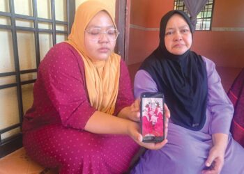SITI Nursyazana Zulkifli (kiri) bersama Noor Zaimah Yunus (kanan) menunjukkan gambar kenangan bersama dua adik-beradiknya yang maut kemalangan di Felda Lepar Hilir 1 di Kuantan, Pahang. - UTUSAN/ DIANA SURYA ABD WAHAB