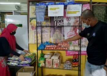 KAMARUL Hisam Sabran dan Zalinda Yusoff menyusun barangan di bank makanan milik mereka di Premis Vendor Rakan Niaga, Jalan Genuang di Segamat, Johor. – FOTO/FARAHWAHIDA AHMAD