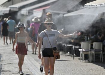 PELANCONG sedang berjalan di sekitar bandar semasa gelombang panas di Athens pada bulan lalu. – AFP