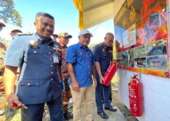 M.AZMAN Taib (tengah) bersama Mohammad Hamdan Wahid (kiri) melakukan simbolik perasmian ‘Fire Point’ Bomba di Kampung Terian, Penampang pada Sabtu.