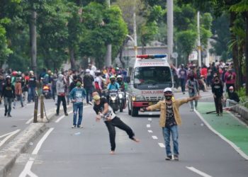 Penunjuk perasaan membaling botol air dan batu ke arah pasukan keselamatan bagi mencetuskan rusuhan di Jakarta, Indonesia. - AFP