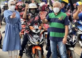 BUNG Moktar (kanan) bersama isterinya, Datin Seri Zizie Izette Abdul Samad (kiri) bersama anak-anak muda bermotosikal semasa program jelajah di kawasan DUN Telok Mas.