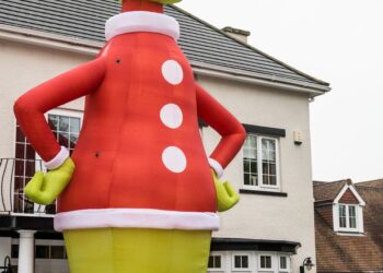 RAY LIDDELL bersama keluarganya berdiri di patung Grinch setinggi 10.668 meter itu. - AGENSI