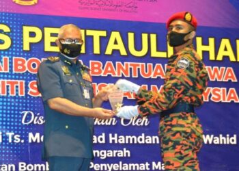 MOHAMMAD Hamdan Wahid menyampaikan anugerah Pelatih Keseluruhan Terbaik Pengambilan Ke-4 Sesi Tahun 2019/2020 kepada Sufi Suprianto Sutijo pada Majlis Pentauliahan Pegawai Bomba Bantuan Siswa USIM di Dewan Tuanku Canselor USIM, Nilai, Seremban hari ini.-UTUSAN/ZAKKINA WATI AHMAD TARMIZI