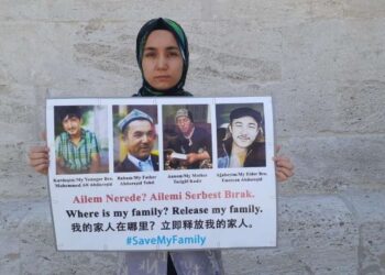 AKTIVIS Uighur, Nursiman Abdureshid memegang poster memaparkan gambar empat ahli keluarga yang dipenjara pemerintah komunis China ketika mengadakan demonstrasi mendesak campur tangan antarabangsa di Turki pada Januari lalu. – SAVEUIGHUR.ORG