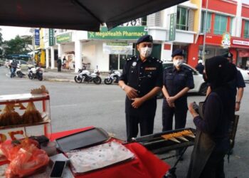 RAHMAT Ariffin membuat pemeriksaan pematuhan SOP dekat sebuah gerai ketika operasi pemantauan dilakukan di Bandar Parklands, Klang, Selangor, semalam.