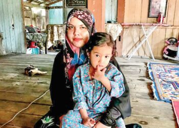 SURIANI Zakaria bersama anak bongsunya, Syafani Syafina Mokhtar di rumahnya di Kampung Kajang Sebidang, Tumpat, Kelantan. - UTUSAN/ ROSLIZA MOHAMED