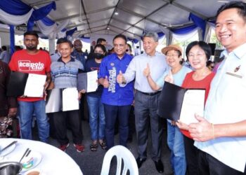REEZAL Merican Naina Merican (lima dari kanan) bersama Mohamad (empat dari kanan) dan Teo Kok Seong (kanan) bersama para penerima surat tawaran program PPR Rantau pada majlis penyerahannya yang diadakan di Rantau, Seremban, hari ini.-UTUSAN/MOHD. SHAHJEHAN MAAMIN.