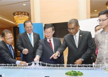 CHOW Kon Yeow, Takiyuddin Hassan dan Baharin Din melihat model projek pengukuhan bekalan elektrik Pulau Pinang yang dibangunkan oleh TNB yang dilancarkan di Pulau Pinang, semalam.