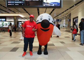TONY Fernandes bersama maskot AirAsia pada majlis meraikan penyambungan semula operasi AirAsia di Terminal 4 Lapangan Terbang Changi, Singapura.