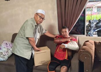 RAZALI Saad (kiri) melawat Muhammad Azrein Puri yang patah tangan selepas melanggar sisa lumpur dalam kejadian di Jalan Alor Setar-Kangar berhampiran Sekolah Menengah Kebangsaan (SMK) Syed Alwi, Kangar, Perlis, pada Sabtu lalu. -UTUSAN