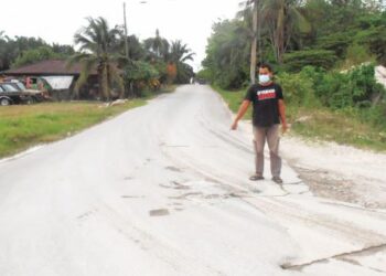 MUHAMMAD Rodzi Abd. Razak menunjukkan keadaan jalan yang rosak dan kotor di Kampung Batu 2 Bawah, Gurun, Sungai Petani, Kedah. - UTUSAN/OTHMAN YAHAYA