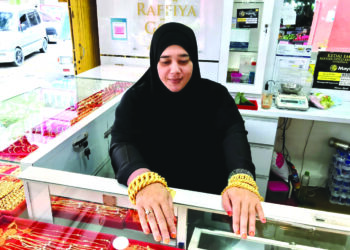 SEORANG peniaga menunjukkan rantai tangan jenis lipan dan coco di kedai emasnya di Kota Bharu. - UTUSAN/ROSLIZA MOHAMED