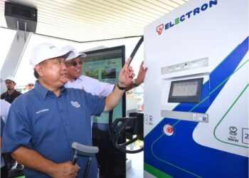 MENTERI Kerja Raya, Datuk Seri Alexander Nanta Linggi (baju biru) dibantu Baharin Din, menguji pengecas DC berkuasa 90kW selepas merasmikan Pengecas Berkelajuan Tinggi TNB Electron di R&R Ayer Keroh (Arah Utara) Melaka, semalam.