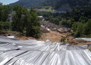 KERJA-KERJA pemasangan kanvas bagi mengurangkan risiko runtuhan tanah giat dilakukan di Jalan Bukit Permai 1, Ampang, semalam. – UTUSAN/SHIDDIEQIIN ZON