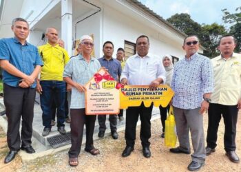 HAMEED Mytheen Kunju Basheer (empat dari kanan) menyerahkan replika kunci kepada seorang penerima bantuan Rumah Prihatin di Kampung Ramuan China Kechil, Lubok China, Melaka.