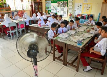 KIPAS tambahan digunakan dalam kelas bagi memastikan pelajar berasa selesa berikutan cuaca panas di Banda Aceh, Indonesia. - AFP