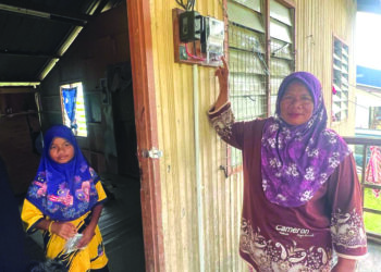 SEORANG penduduk Orang Asli menunjukkan meter elektrik yang dipasang di rumahnya di Pos Tuel, Gua Musang, Kelantan. – UTUSAN/AIMUNI TUAN LAH