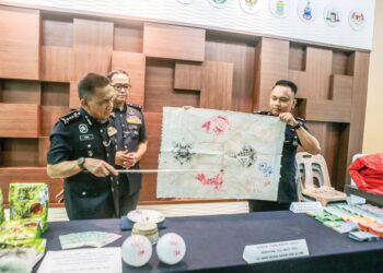 FISOL Salleh (kiri) menunjukkan peralatan yang digunakan dalam permainan judi belangkas dalam satu serbuan di Kampung Titi Akar, Pendang. - UTUSAN/ SHAHIR NOORDIN