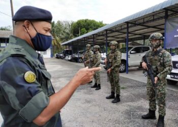 AZHARI (kiri) memberi taklimat kepada anggota PGA dan ATM yang melakukan penugasan bersama menerusi Op Bersepadu di Martek PGA Lubok Stol, Rantau Panjang, Kelantan. - UTUSAN/YATIMIN ABDULLAH