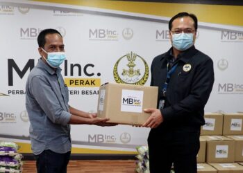 ANUAR  Zainal Abidin  (kanan) menyempurnakan simbolik penyerahan sumbangan 50 kotak makanan kepada Sayed Hesyam Idris di Ipoh hari ini. - UTUSAN/ZULFACHRI ZULKIFLI