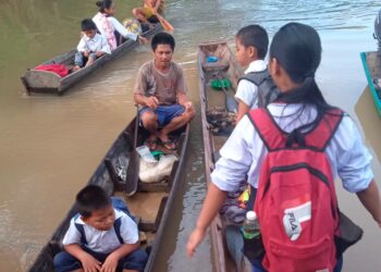 MURID SK Pinapak menaiki perahu menyusuri Sungai Bengkoka, Pitas untuk ke sekolah. – MINGGUAN/SURAIDAH ROSLAN