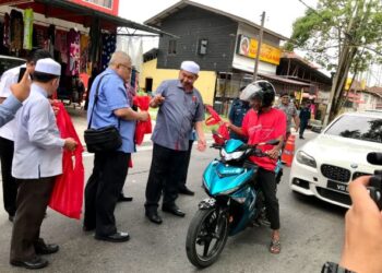 DR Izani Husin (dua dari kanan) menyerahkan beg guna pakai semula kepada penunggang motosikal pada Majlis Pelancaran Penutupan Kempen Kesihatan Persekitaran Tahun 2022 dan Kempen Bebas Plastik, Polisterin dan Penyedut Minuman di Dataran Muhammadi, Kota Bharu, Kelantan.UTUSAN/ROSLIZA MOHAMED