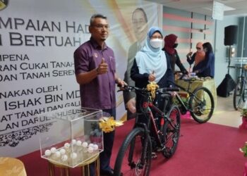 MOHD. Nizam Tajul Arus (kiri) menyampaikan hadiah basikal kepada seorang pembayar cukai tanah dalam cabutan bertuah sempena Kempen Jom Bayar Cukai Tanah Daerah Seremban 2022 di Seremban hari ini.-UTUSAN/NAZARUDIN SHAHARI