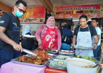 NOOR AZIZAH Ariffin bersama Mohd. Usman Majid (kanan) tidak menang tangan menguruskan perniagaan nasi campur di Medan Selera Taman Siakap, Butterworth, Pulau Pinang.