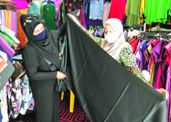 NIK Zawiah Nik Hasan (kanan) melayan pelanggan di kedainya di kawasan bebas cukai Pengkalan Kubor, Tumpat, Kelantan. – mingguan/ROSLIZA MOHAMED