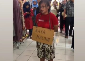 TANGKAP layar video menunjukkan seorang wanita diarak keliling pasar sambil memakai plakad tertulis ‘saya pencuri’. - AGENSI