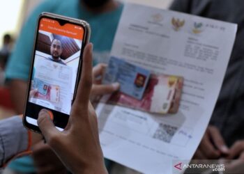 SEORANG kakitangan merakam gambar penerima bantuan sosial di Sanur, Denpasar di Bali pada Julai 2021. -ANTARA  