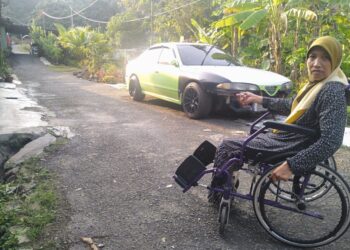 ROZLINA Ismail menunjukkan laluan ke rumah sewanya yang berbukit sekali gus sukar untuk bergerak di Kampung Melayu di Jerantut, Pahang. - UTUSAN /HARIS FADILAH AHMAD