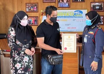 SAYANI Saidon menyampaikan sijil penghargaan khas kepada Mohd Anuar Ahmad yang menyelamatkan seorang kanak-kanak autisme yang hampir lemas dalam kejadian di Alor Setar hari ini. - UTUSAN/JAMLIAH ABDULLAH