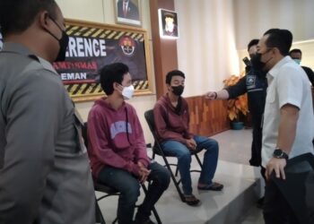 SUSPEK (pelitup muka putih) ketika ditahan polis kerana mendakwa dirinya menjadi mangsa pukul kumpulan samseng di Yogyakarta, Indonesia. - AGENSI