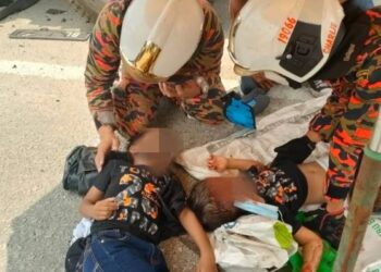 ANGGOTA bomba memberi rawatan awal kepada dua kanak-kanak yang terlibat kemalangan kereta dipandu bapa mereka di Taman Chepor Impian di Ipoh hari ini. - UTUSAN