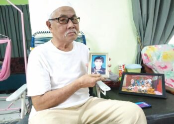 OMAR Yuhyi menunjukkan gambar Sheikh Faeizan ketika berusia 19 tahun di rumahnya di Kampung Paya Embun, Pekan Nanas, Pontian, Johor.