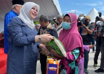 RINA  Mohd. Harun (kiri) menyampaikan bakul makanan kepada salah seorang ibu tunggal di Rumah Tamu KADA, Kampung Nibong, Bachok, Kelantan.