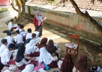 MURID-murid terpaksa belajar di bawah pokok disebabkan keadaan kelas yang rosak di Kabupaten Cianjur, Jawa Barat.-KOMPAS