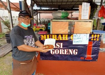 MOHD. Rizal Baharuddin menunjukkan nasi goreng yang dijualnya di warung makanan berdekatan Kolej Vokasional Ampangan, Seremban. - UTUSAN/ZAKKINA WATI AHMAD TARMIZI