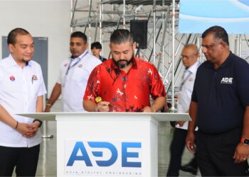 TUNKU Ismail Sultan Ibrahim menandatangani plak sambil diperhatikan oleh Tony Fernandes (kanan) dan Onn Hafiz Ghazi (kiri) pada Majlis Pelancaran Hangar Asia Digital Engineering (ADE) Senai di Lapangan Terbang Antarabangsa Senai. – UTUSAN/RAJA JAAFAR ALI