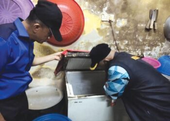 DR. Zaini Hussin (kiri) semasa melakukan pemeriksan ke atas sebuah premis makanan di Kota Bharu, Kelantan. - IHSAN JKNK