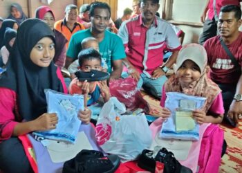 NURUL Syazwani Mohamad Shauti (kiri) dan adiknya, Nurul Hasnah teruja menerima sumbangan pakaian sekolah yang disampaikan pihak Kelab WMC Kelantan di kediaman mereka di Kampung Serungga, Gual Periuk, Rantau Panjang, Kelantan. – MINGGUAN/ROSALWANI CHE SOH